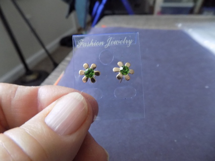 pair of goldtone daisy shape post earrings with green rhinestone center