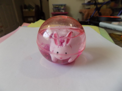 Pink see through 2 1/2 inch ball with white rabbit and lots of pink glitter inside