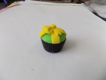 1 inch round mini rubber cupcake with green icing, yellow bow, black paper