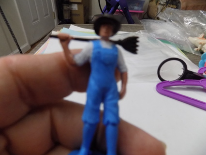 2 1/2 inch tall Farmer dressed in blue bibbs outfit and white shirt holds rake