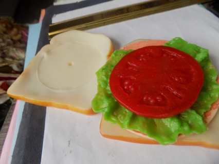 Realistic looking fake sandwhich, has bread, tomato,lettuce,bologna, cheese